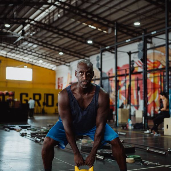 A focused man lifting a kettlebell, demonstrating strength and concentration.